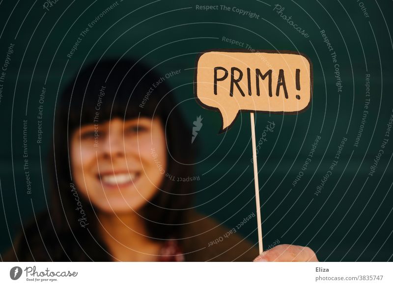 Laughing woman holds a speech bubble in which Prima stands. Communication, joy, praise and satisfaction. communication Positive Approval Joy laud Speech bubble
