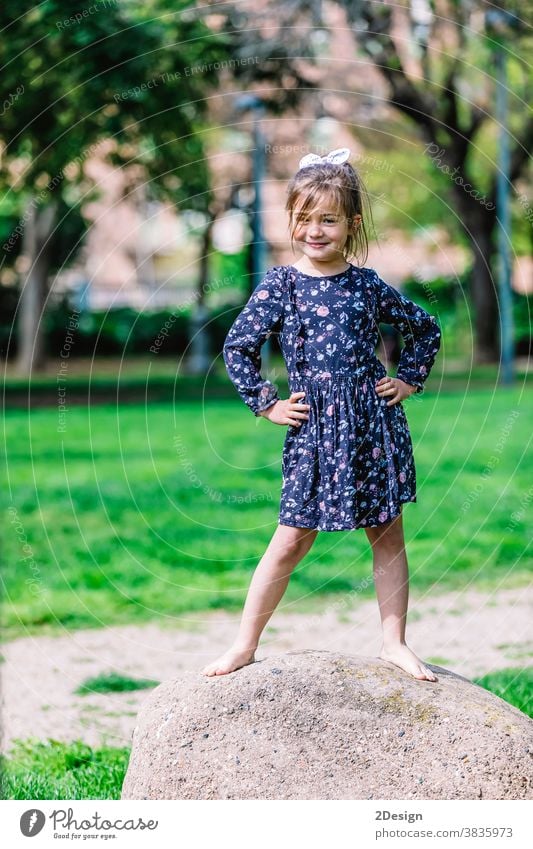 Portrait of a pretty smiling little child girl standing in park outdoors. young adorable childhood cheerful person toddler cute happy boy beautiful portrait