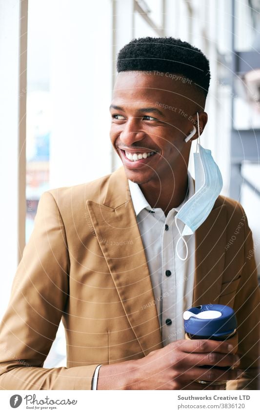 Portrait Of Young Businessman Wearing Mask Holding Coffee Standing In Modern Office During Pandemic business businessman face mask face covering wearing ppe