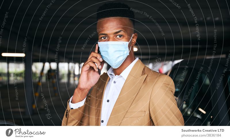 Businessman Wearing Mask Using Mobile Phone In Airport Car Park During Health Pandemic business businessman face mask face covering wearing ppe car park parking