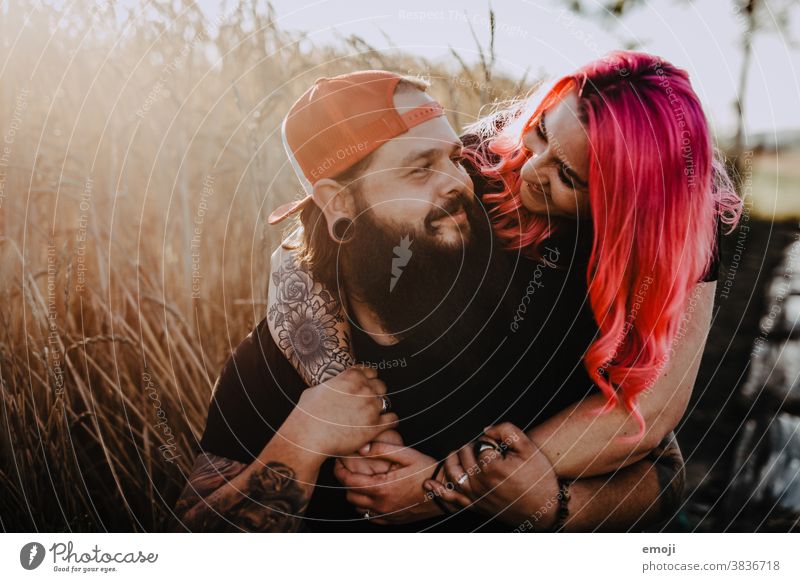 Couple with tattoos and pink hair in a cornfield - a Royalty Free Stock Photo from Photocase