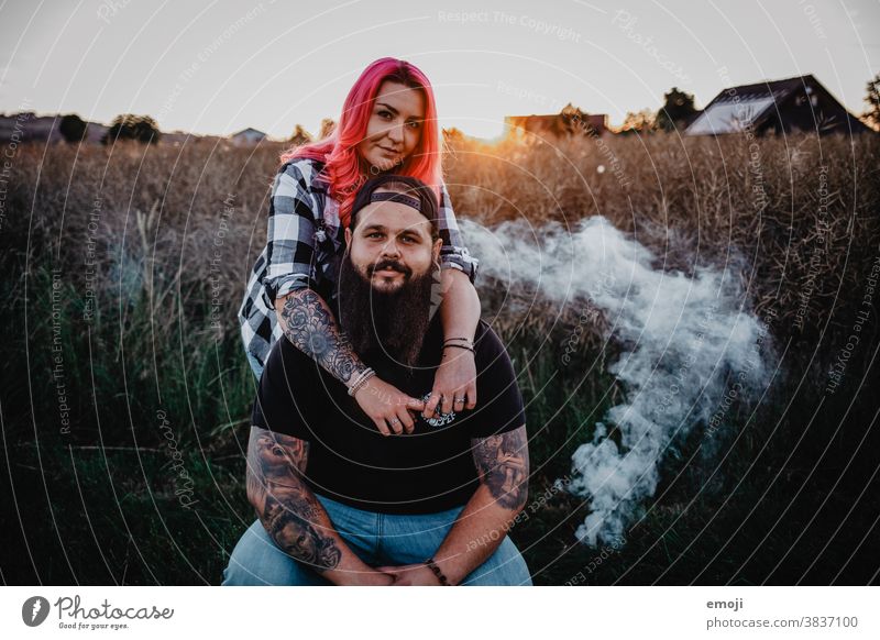 Couple with tattoos and pink hair at sunset Woman Man Hipster Hip & trendy Cuddling heartfelt Tattoo Cornfield Field out Love In love teen proximity