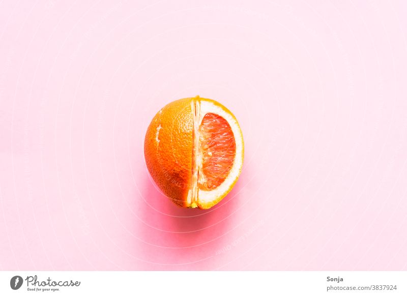 A sliced grapefruit on a pink background. Grapefruit Raw Citrus fruits Nutrition Colour photo Healthy Eating Organic produce Vegetarian diet Vitamin Vitamin C