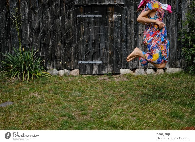 Jumping child in front of the wall of an old barn Child Hop Playing Happiness fun game Dress up variegated Grass Lawn Garden Summer Green broached Girl Joy
