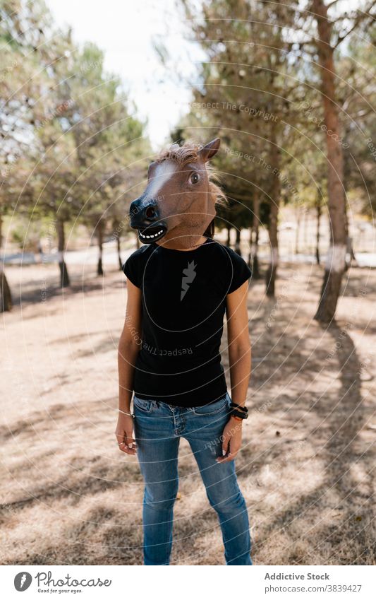 Man in horse mask in park creative bizzare man weird rubber character disguise funny male funky sunny animal head nature hide carnival festive strange guy nerd