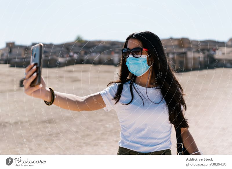 Woman in mask taking selfie in town self portrait smartphone woman coronavirus covid 19 epidemic using take photo female sunny street young medical device