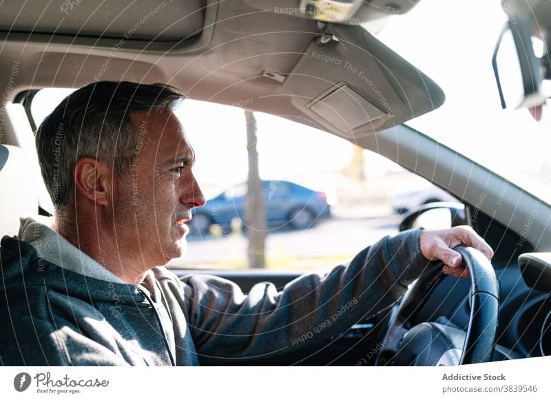 Senior retired man driving car steering wheel pilot traffic healthy vision reflexes senior 60 journey person horizontal one person happy old car insurance