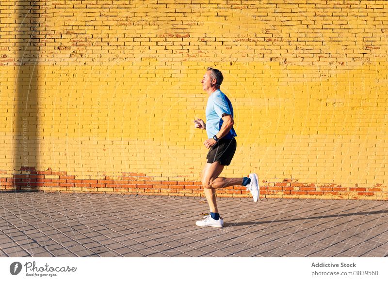 Senior retired man running through the city on yellow background 60 58 rest rythm health care fitness high-blood-pressure training cardiac old neck rate