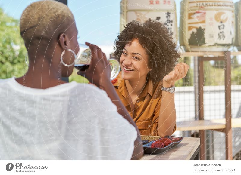 Women with wineglasses in cafe clink women friend celebrate festive ethnic black african american drink happy cheerful terrace table beverage friendly smile