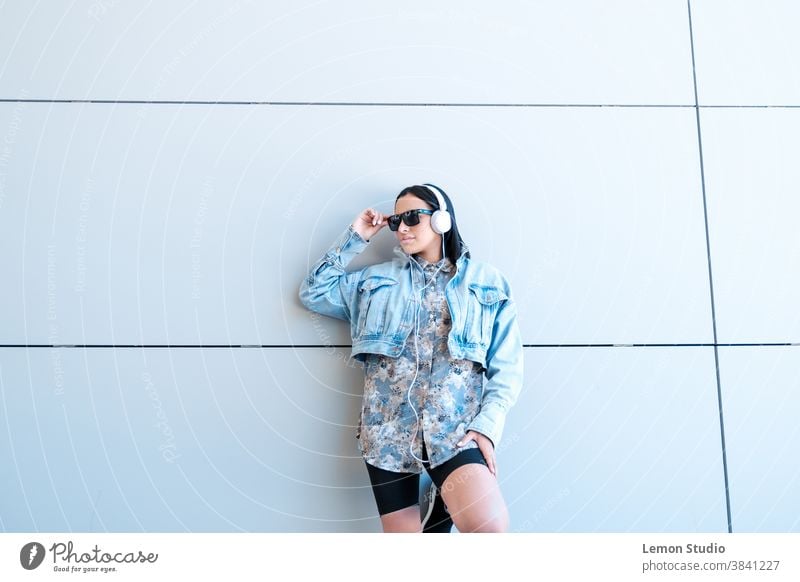 Latin American woman with black sunglasses listening to music on a grey background. Happy people sesion Gray Music Lenses Woman posing Happy Birthday