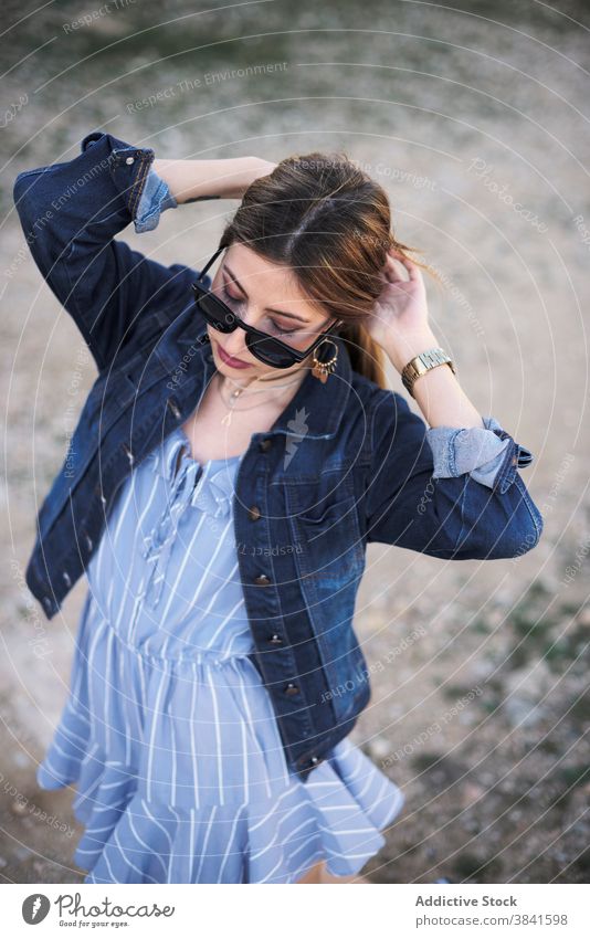 Stylish woman in denim jacket in nature style carefree tranquil trendy cool sunglasses female casual fashion young rest enjoy relax charming serene weekend