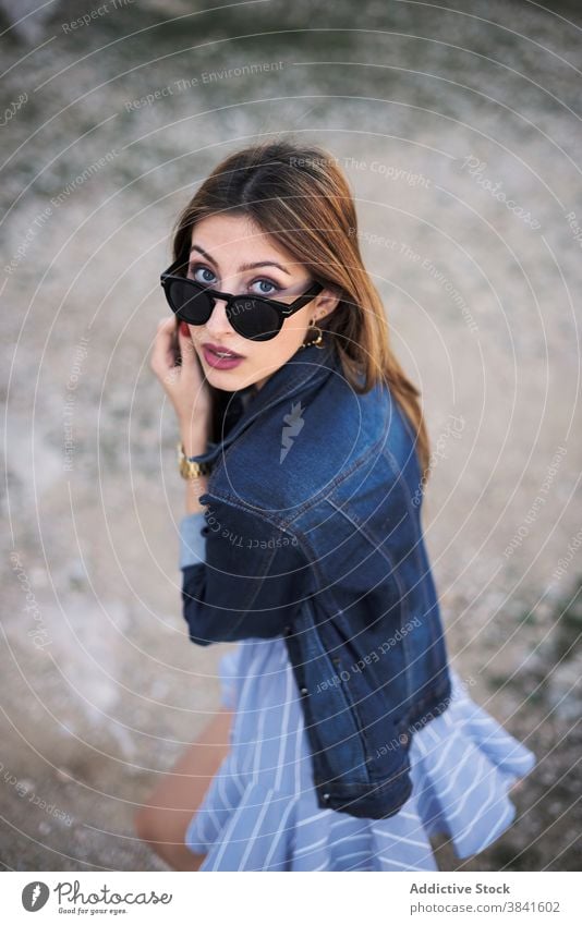 Stylish woman in denim jacket in nature style carefree tranquil trendy cool sunglasses female casual fashion young rest enjoy relax charming serene weekend
