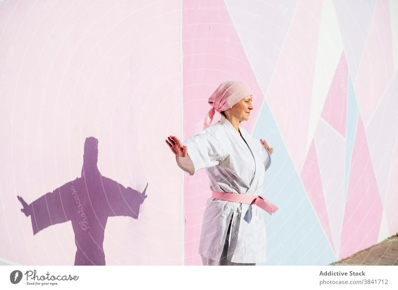 Karate woman who has defeated cancer karate martial sport campaign awareness health female fighter pink foulard confident disease remission strong oncology