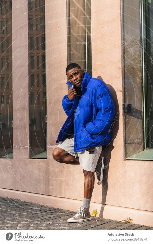 Black stylish man in warm jacket on street style warm clothes handsome outerwear city confident male ethnic black african american vivid blue color fashion