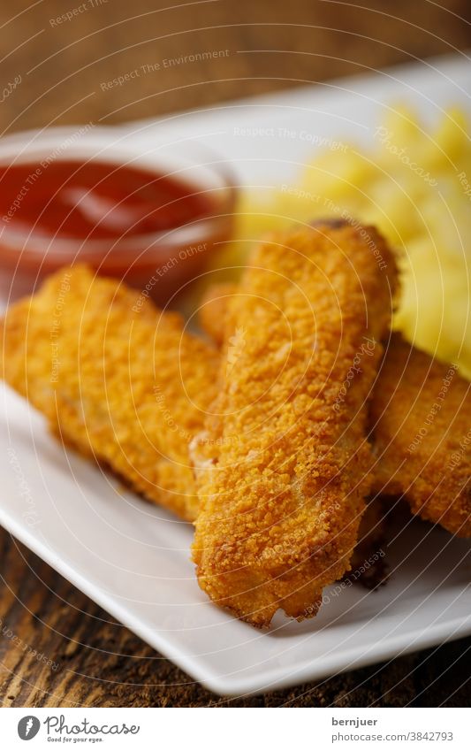 Fish fingers with potato salad on the plate Breadcrumbs Style Appetizer background Close-up Brown Children's menu grilled golden fish sticks children's food