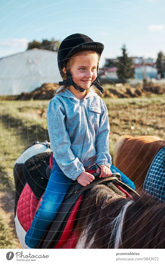 Little smiling girl learning horseback riding kid ride practice school cute country pretty rural ranch lesson rider happiness countryside active equestrian