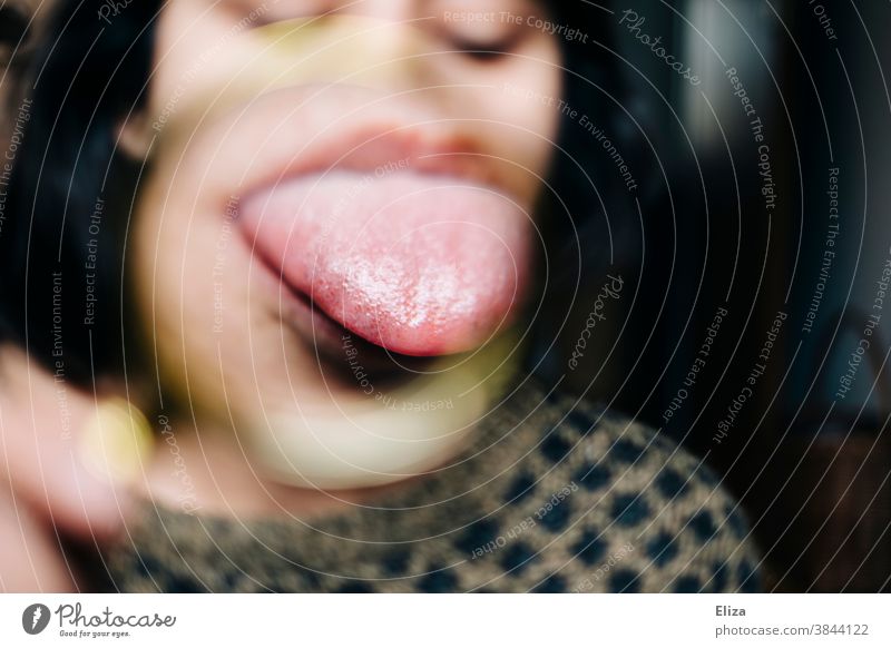 Woman sticks out her tongue, magnified by a magnifying glass stick out one's tongue Magnifying glass Enlarged Funny warped Face Tongue Near Mouth Brash Grimace