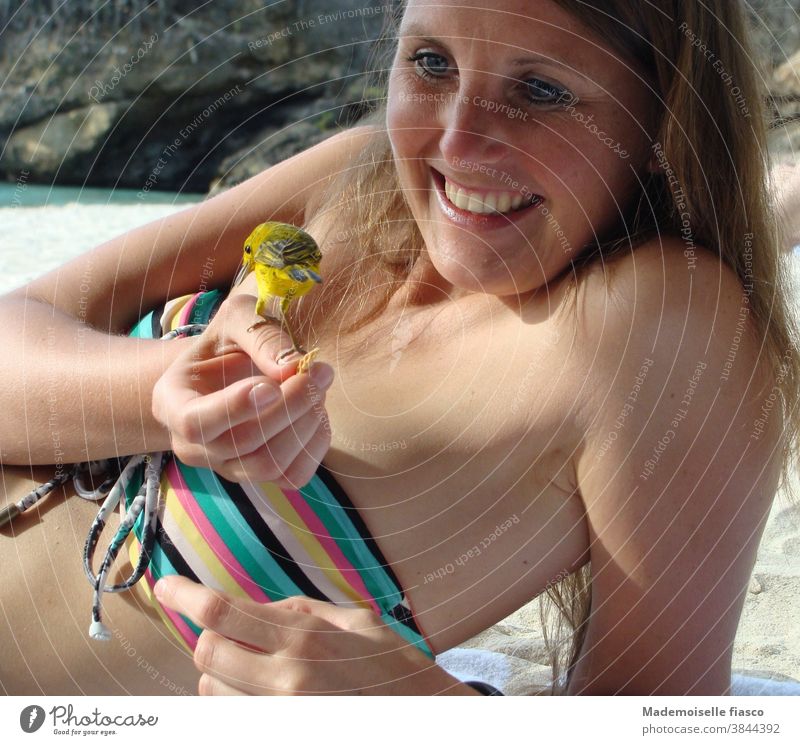 Bird sitting on hand of woman on the beach Bikini Young woman Beach Vacation & Travel Caribbean Summer vacation Sunlight Skin Feminine Joy Exterior shot
