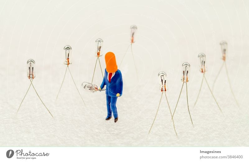 Miniature light bulbs and miniature figure with cap holding a light bulb. minimal abstract Creative idea concept Subminiature Electric bulb Abstract creatively