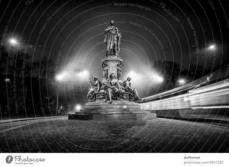 Black and white photo with long time exposure of a monument at night Black & white photo Long exposure Tram Night Light Munich Monument Rush hour Statue