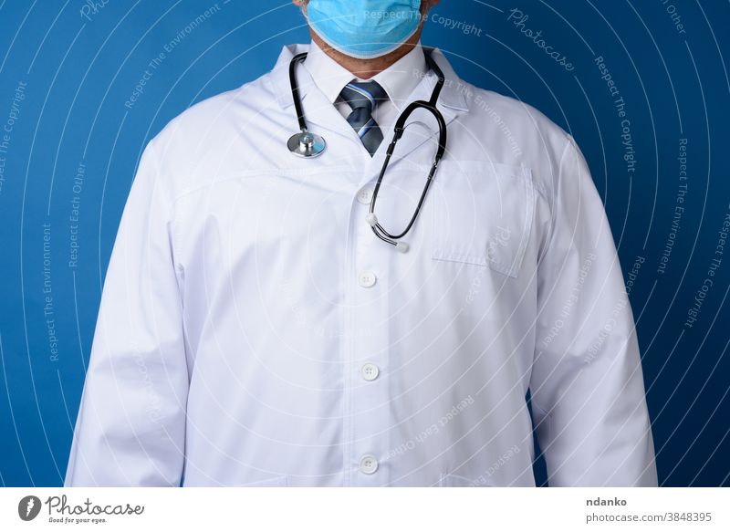 doctor in a white coat stands on a blue background adult cardiologist care caucasian clinic expertise front health healthcare hospital illness indoors job male