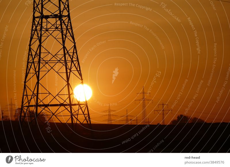 Sunset behind power pole -orange sky, one high voltage pole in the foreground, cut, several poles in the background Electricity pylon Orange Back-light