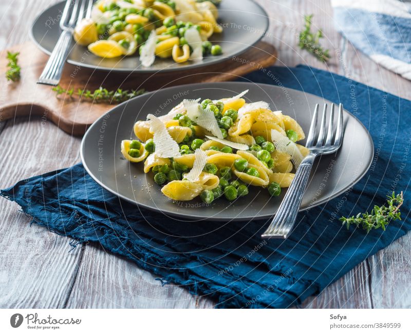 Italian orecchiette pasta with peas and cheese food italian cuisine macaroni pecorino shred grate vegetable cook dish wooden table lunch meal first course