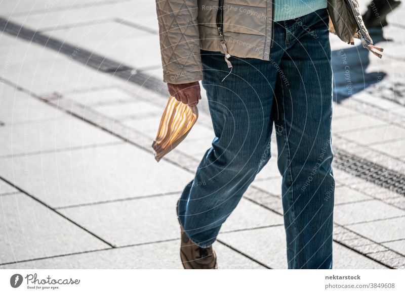 Person Holding Mask in Hand Outside new normal mask hand medium shot street walking day sunny spring unrecognizable people restriction lockdown jeans holding