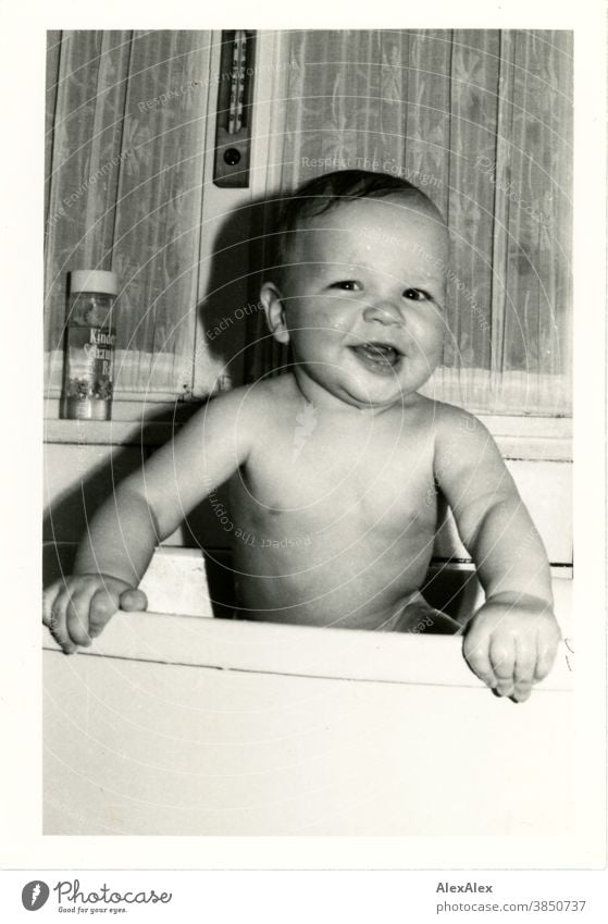 A little boy bathing in a plastic bathtub holds on to the edge and smiles broadly into the camera Baby Toddler Boy (child) 1 - 3 years Smiling Joy neat