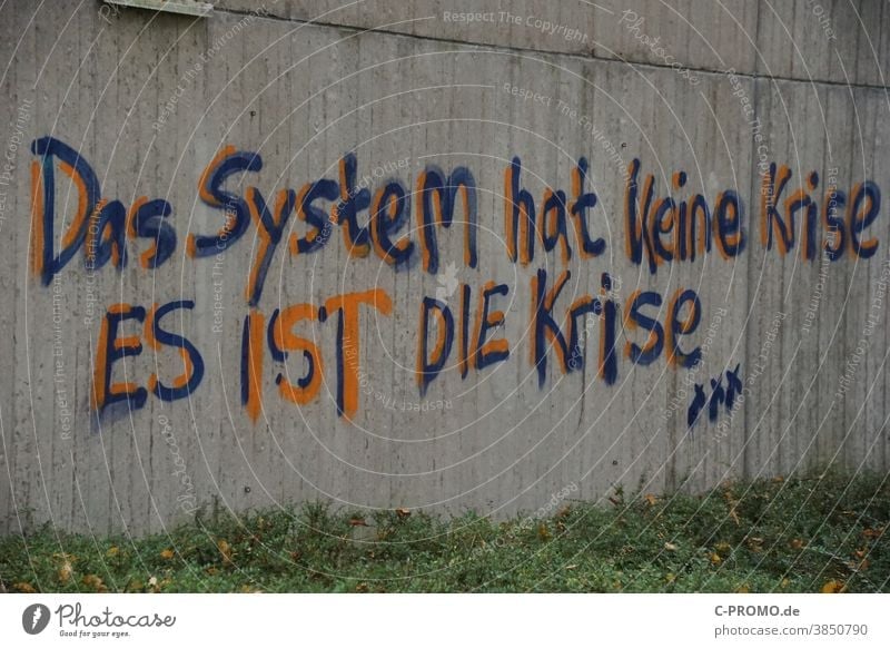 System criticism on house wall Crisis System analysis Concrete Graffiti saying The system does not have a crisis - it is the crisis critique of capitalism