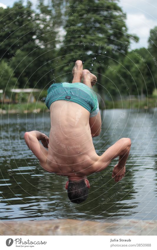 Man does a somersault into a bathing lake Swimming trunks Natural lake Vacation & Travel Relaxation Exterior shot Summer Summer vacation Summery Water