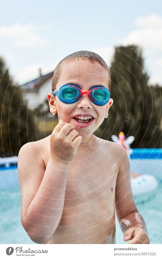 Happy boy playing in a pool authentic backyard childhood children family fun garden happiness happy joy kid laughing lifestyle playful real recreation relaxing