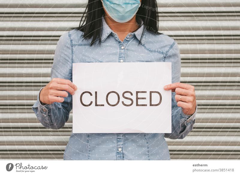 Coronavirus.Woman with medical face mask holding a White cardboard with the text closed coronavirus woman protective surgical mask closed shop business