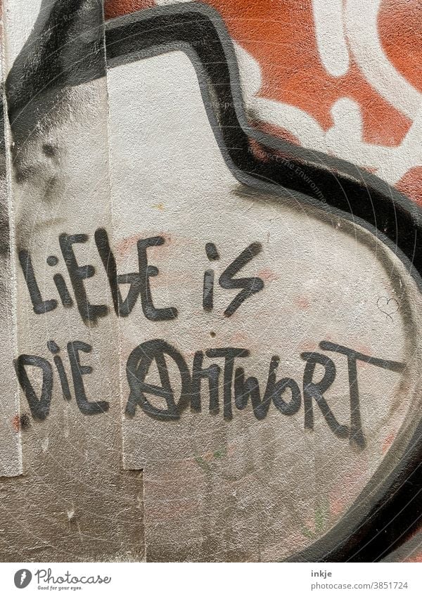 German graffiti on the facade Colour photo Exterior shot Graffiti Love saying Answer Meaning Facade writing urban meaning of life antifa policy harmony