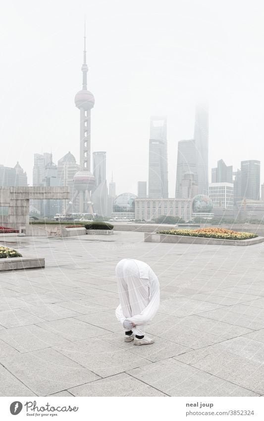 Yoga pose in front of the skyline of Shanghai prevention Acrobatic Skyline China Tourist Attraction Pu Dong Deserted in the morning foggy Moody tranquillity