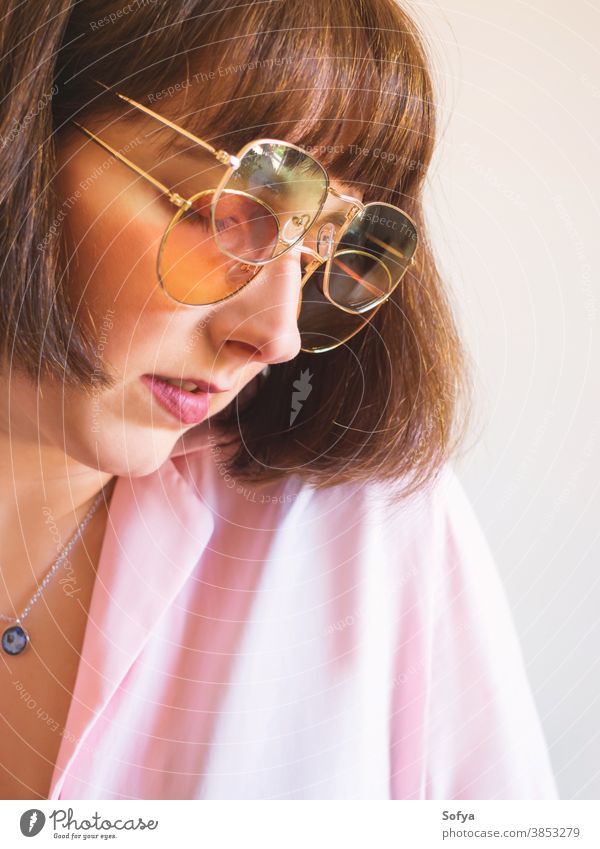 Young woman in pink shirt with sunglasses young fashion accessory autumn spring transparent retro vintage girl brunette face smile fun funny lady wear hipster