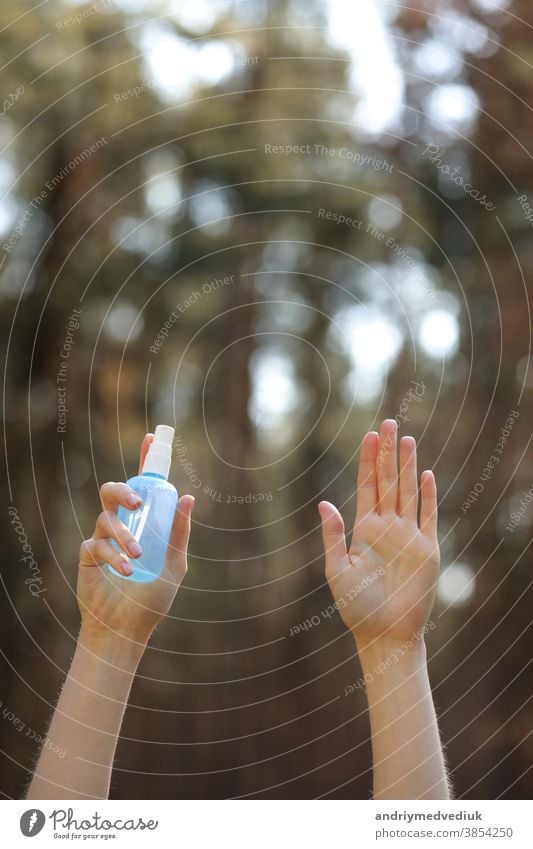 woman hands holding alcohol spray or anti bacteria spray outdoor to prevent spread of germs, bacteria and virus, quarantine time, focus on close up hands. coronavirus. copy space