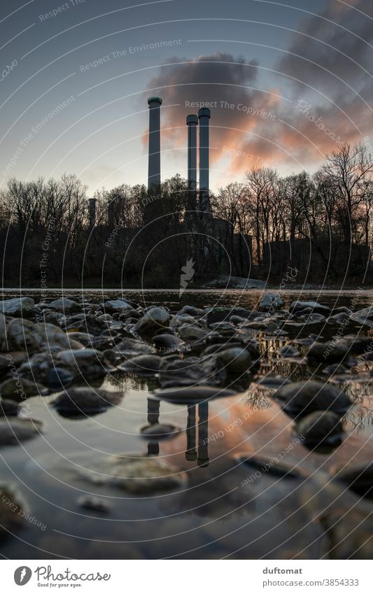 Reflection of a power plant on stone floor at dusk Lakeside Surface of water reflection power station out bank Thermal power station stones spires Mirror image