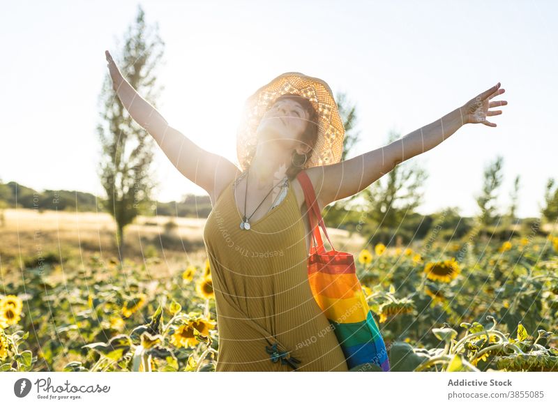 woman relaxing in sunflower field enjoy nature bloom season sunny carefree female rainbow bag stand calm weather tranquil peaceful freedom serene lady harmony