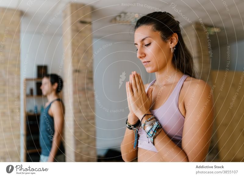 Woman meditating during yoga lesson woman meditate studio hands clasped practice zen spirit female young group balance vitality wellbeing relax calm harmony