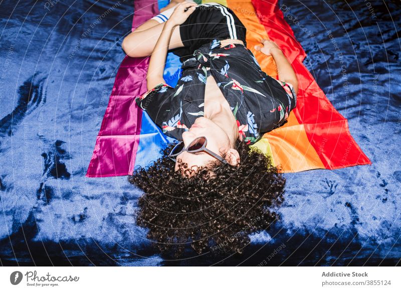 Relaxed female lying on LGBT flag on bed woman equal rainbow homosexual respect tolerance upside down right community gender solidarity same sex discriminate
