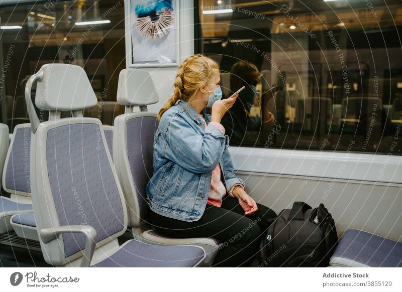 Woman recording audio message on smartphone in train woman passenger voice using covid19 transport female traveler covid 19 coronavirus connection internet