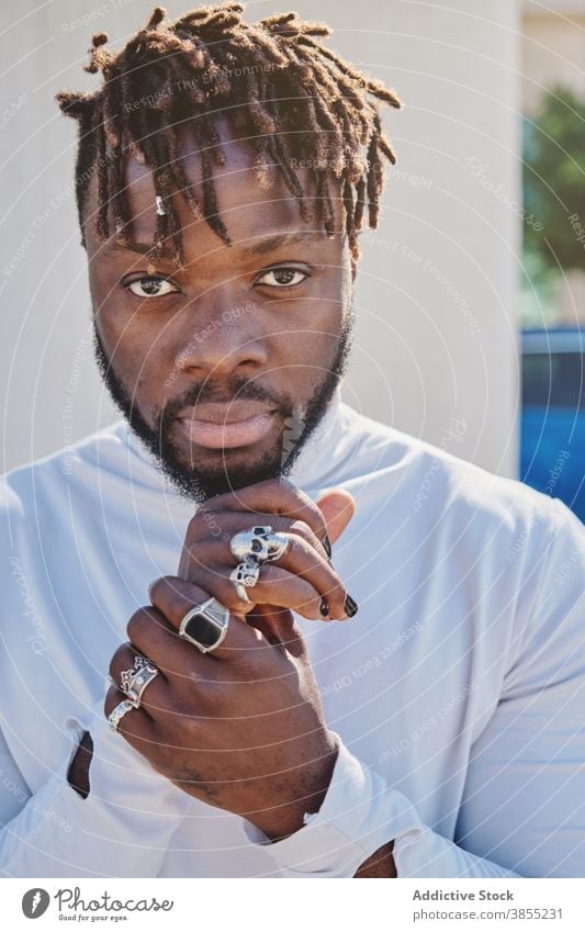 Stylish black man with unusual appearance dreadlocks manicure fancy style hairstyle ring hipster portrait male ethnic african american fashion trendy cool
