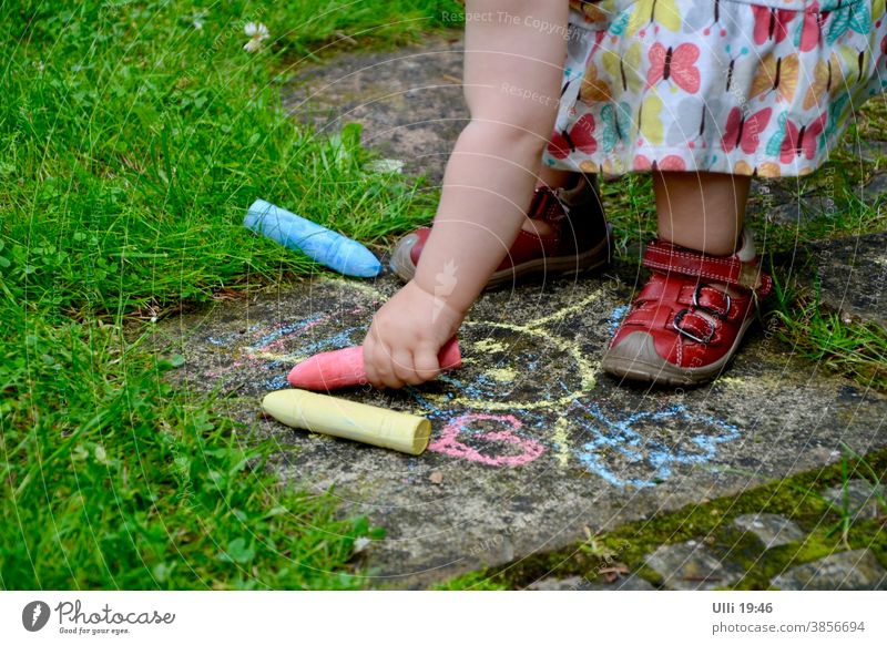 Child paints an old garden path color matching dress....... Childlike Summer's day Garden Garden path Stone slab Draw crayons Blue Red Grass Green space Toddler
