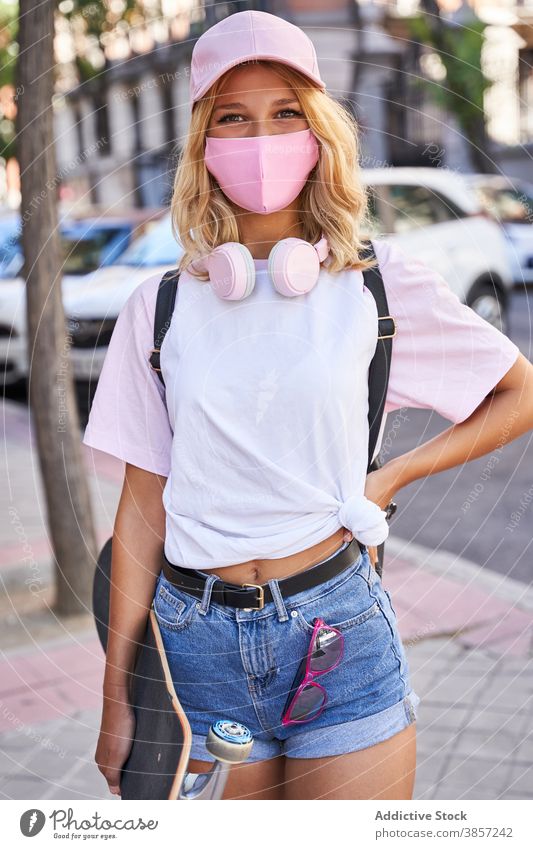 Happy female teen in protective masks standing in city urban summer coronavirus trendy street pandemic blonde girl adolescent hat teenage woman young happy