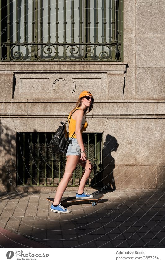 Young hipster female skater on city street woman teenage skateboard urban trendy ride summer style lifestyle modern contemporary young activity cool carefree