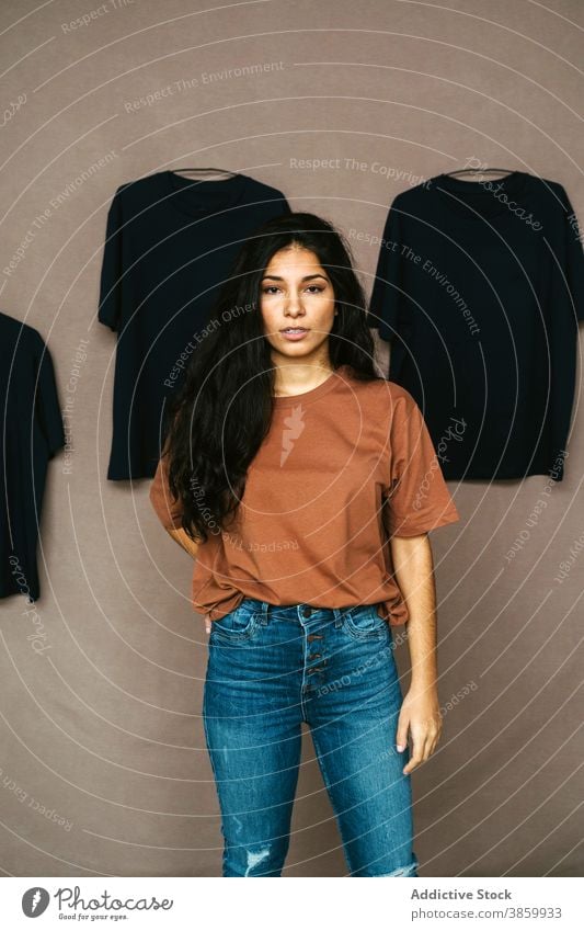Ethnic woman in casual clothes in studio t shirt creative model wall art style outfit female ethnic stand young modern trendy slim fashion cool enjoy relax
