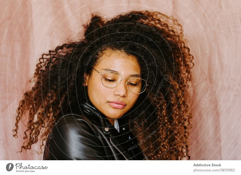 Stylish black woman in leather jacket in studio style afro hairstyle trendy casual young carefree female ethnic african american outfit cool modern stand