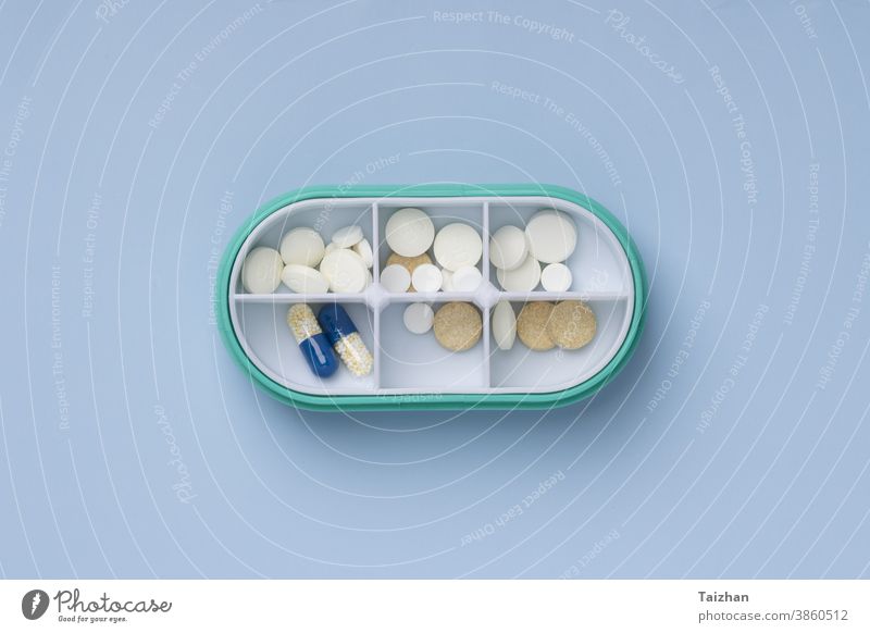 Daily pill box with medical pills   on blue background. Top view. Flat lay medicine day organiser health care note reminder write daily medication open