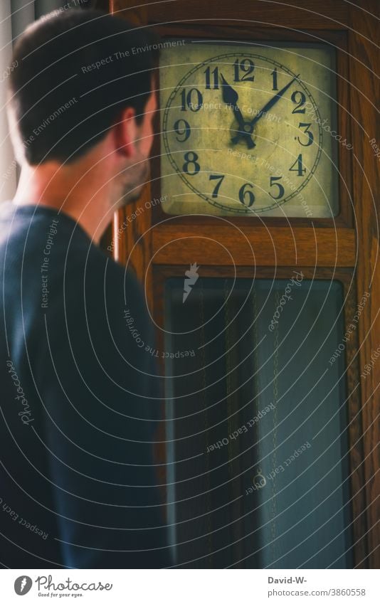 Man looks at a grandfather clock and reads the time Clock Time planning Clock hand Digits and numbers Transience Haste Stress Nostalgia